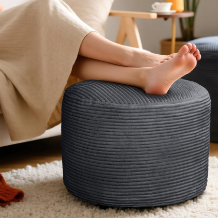 Soft corduroy round pouf foot rest filled with shredded foam, cozy cushioned hassock stool beside sofa